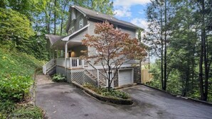 A two-story house with a front porch, a staircase, and a garage.