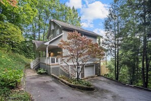 A two-story house with a front porch, a staircase, and a garage.