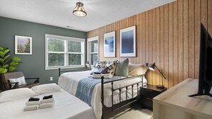 A hotel room with a bed, bedside table, lamp, and a TV.