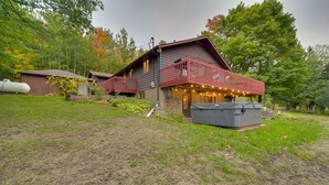 Un rustico chalet con un balcone rosso, una zona salotto all'aperto coperta e un serbatoio d'acqua di grandi dimensioni sullo sfondo.