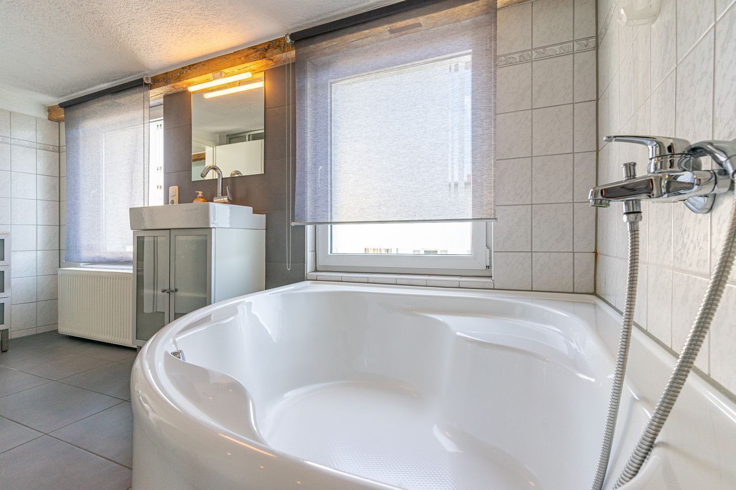 Une salle de bain moderne dotée d’une grande baignoire, d’une fenêtre offrant une belle vue et d’un espace douche.