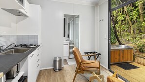 Une cuisine moderne dotée d’une cuisinière intégrée, d’une poubelle et d’un coin salon offrant une vue sur l’extérieur.