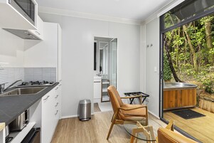 Una cocina moderna con estufa integrada, un basurero y una zona de estar con vistas al exterior.