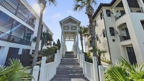 A wooden pathway leading to a gated entrance with a sign that reads "Welcome."