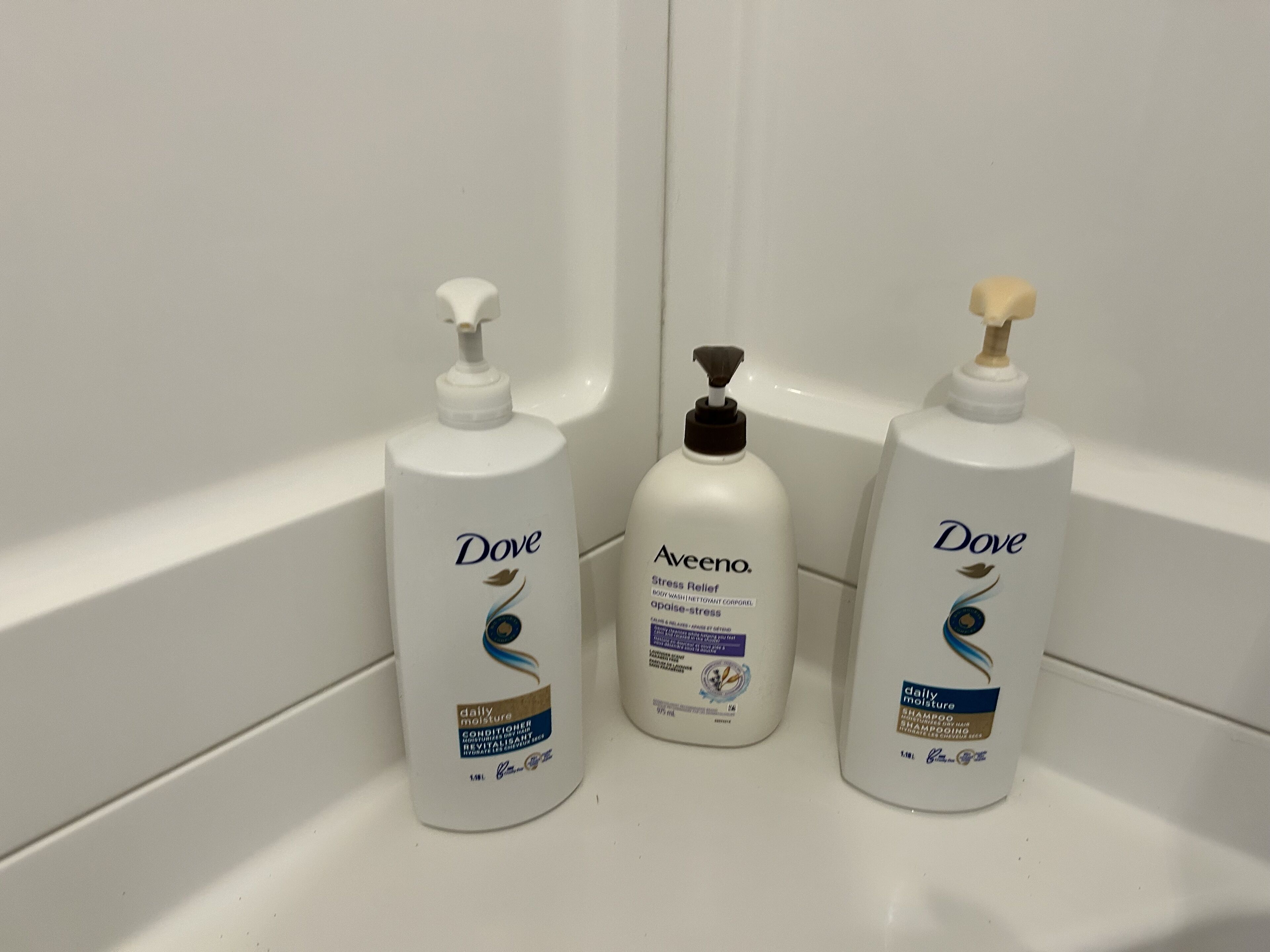 Tre prodotti di bellezza e cura personale Dove in un bagno.