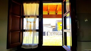 A doorway with a wooden frame and a window with sheer curtains. - El Jardín de Casa Male (Pimiango)