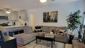 A modern living room with a sectional sofa, a coffee table, and a ceiling fan.
