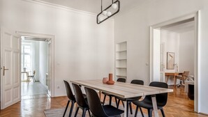 A dining area with a wooden table, black chairs, and a modern pendant light. - Terrific Landstraße 2BR w/ Elevator, nr Tram & Dining, by Blueground (Vienna)
