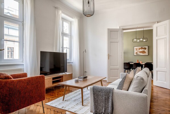 Relax in this stylish living room with a flat-screen TV, comfortable sofa, and dining area.