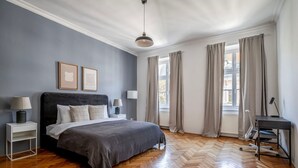 A bedroom with a large bed, bedside tables, a desk, and a window with curtains. - Terrific Landstraße 2BR w/ Elevator, nr Tram & Dining, by Blueground (Vienna)