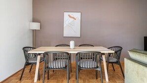 A dining area with a wooden table, six chairs, a vase, and a painting on the wall. - Airy Döbling 3BR w/ Balcony & Elevator, nr Restaurants, by Blueground (Vienna)