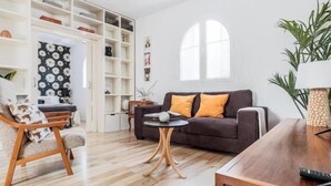 A modern living room with a brown sofa, a wooden coffee table, and a white shelving unit. - Spectacular duplex with private terrace (Sevilla)