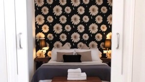 A bedroom with a bed, bedside tables, and a bench with towels. - Spectacular duplex with private terrace (Sevilla)
