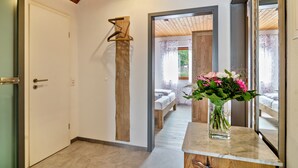 A hallway with a wooden ceiling, a bed with a wooden headboard, and a vase with flowers on a marble table. - Apartment "Panorama View" with Shared Garden, Balcony, and Wi-Fi (Salem)