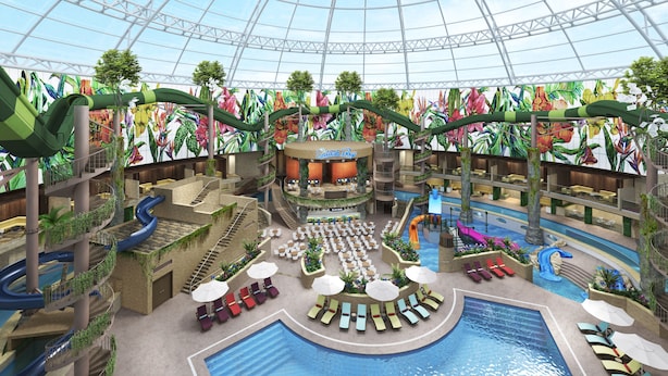 Un complex turístic interior amb diversos nivells, una piscina central, tobogans i una zona d'escenari.