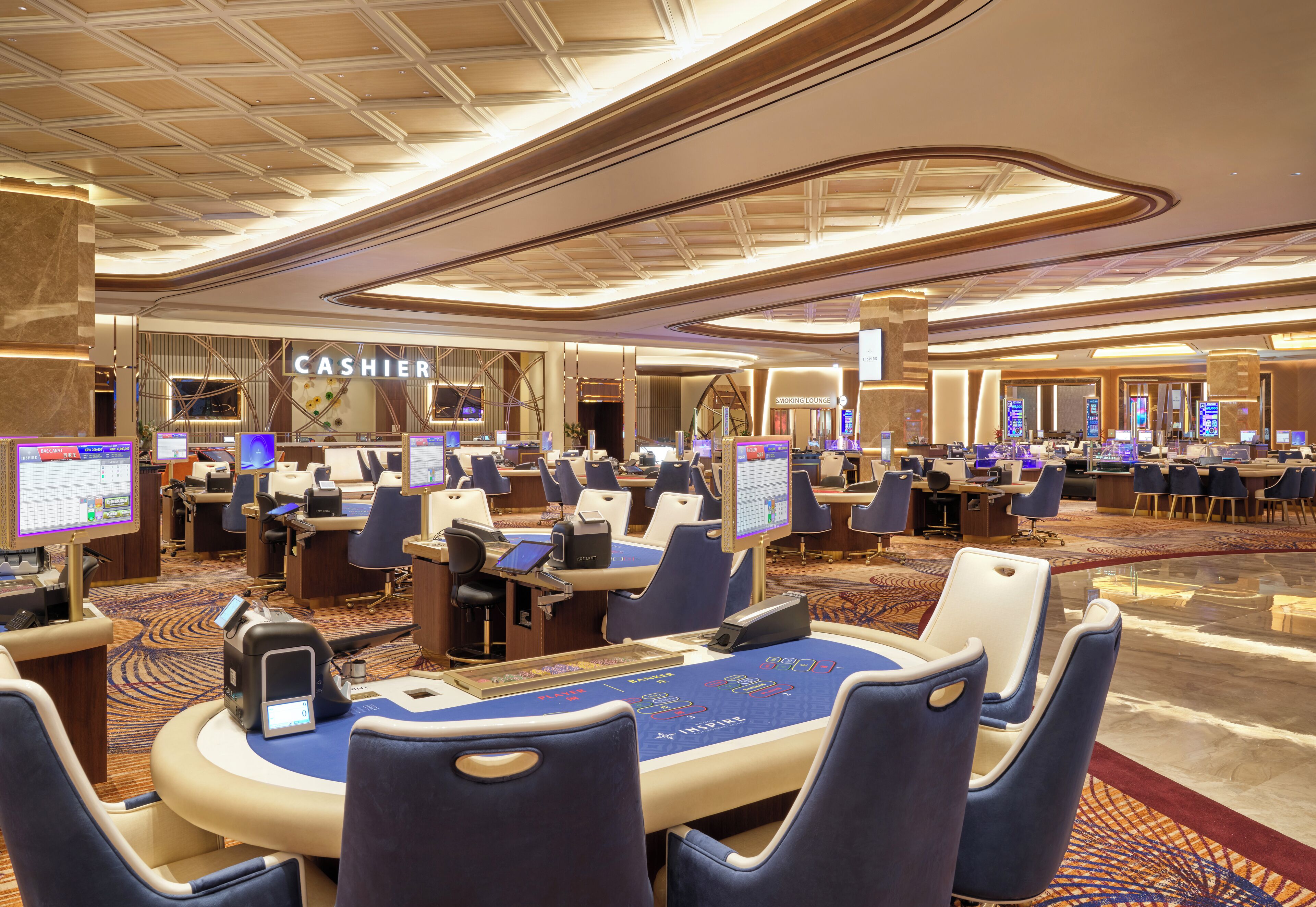 A modern casino with multiple gaming tables and a prominent cashier area.