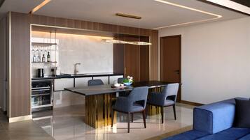 A modern kitchen with a central island, built-in wine rack, and a dining area with a sofa and chairs.