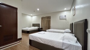 A hotel room with two beds, a wardrobe, a bedside table, a wall-mounted air conditioner, and a curtain. - Asia Jem Hotel-Gapan City (Gapan City)