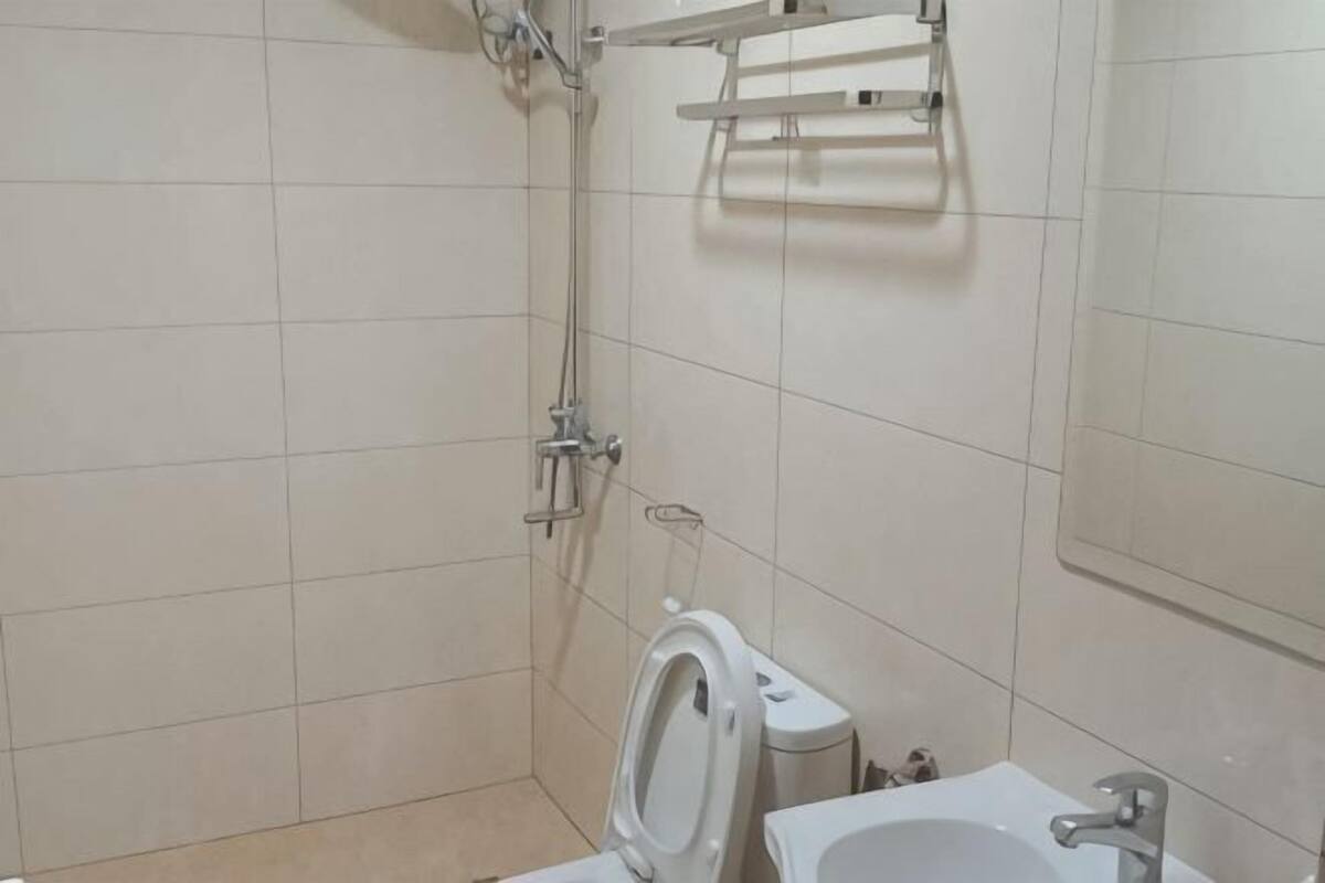 A bathroom with a shower, toilet, and sink.