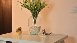 Ein Tisch mit einer Blumenvase und zwei Vogelstatuen.