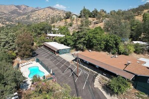 A residential property with a swimming pool, parking lot, and a building with a red roof. - The Belle Sequoia Motel RM9 (Three Rivers)