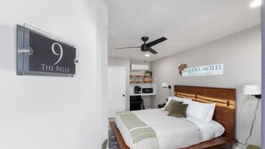 A hotel room with a bed, a ceiling fan, a sign indicating the room number, and a sign for the motel. - The Belle Sequoia Motel RM9 (Three Rivers)