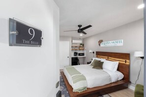 A hotel room with a bed, a ceiling fan, a sign indicating the room number, and a sign for the motel. - The Belle Sequoia Motel RM9 (Three Rivers)