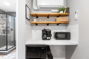 A modern kitchen with a coffee maker, microwave, and a glass shower enclosure. - The Belle Sequoia Motel RM9 (Three Rivers)