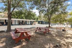 A motel with outdoor picnic tables, a pool area, and a fenced playground. - The Atwell at the Sequoia Motel (Three Rivers)