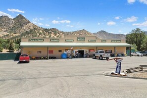 A commercial building with multiple business signs including Farm & Ranch, Hardware, Plumbing, Mercantile, Electrical, Paint, and Lawn & Garden. - The Atwell at the Sequoia Motel (Three Rivers)