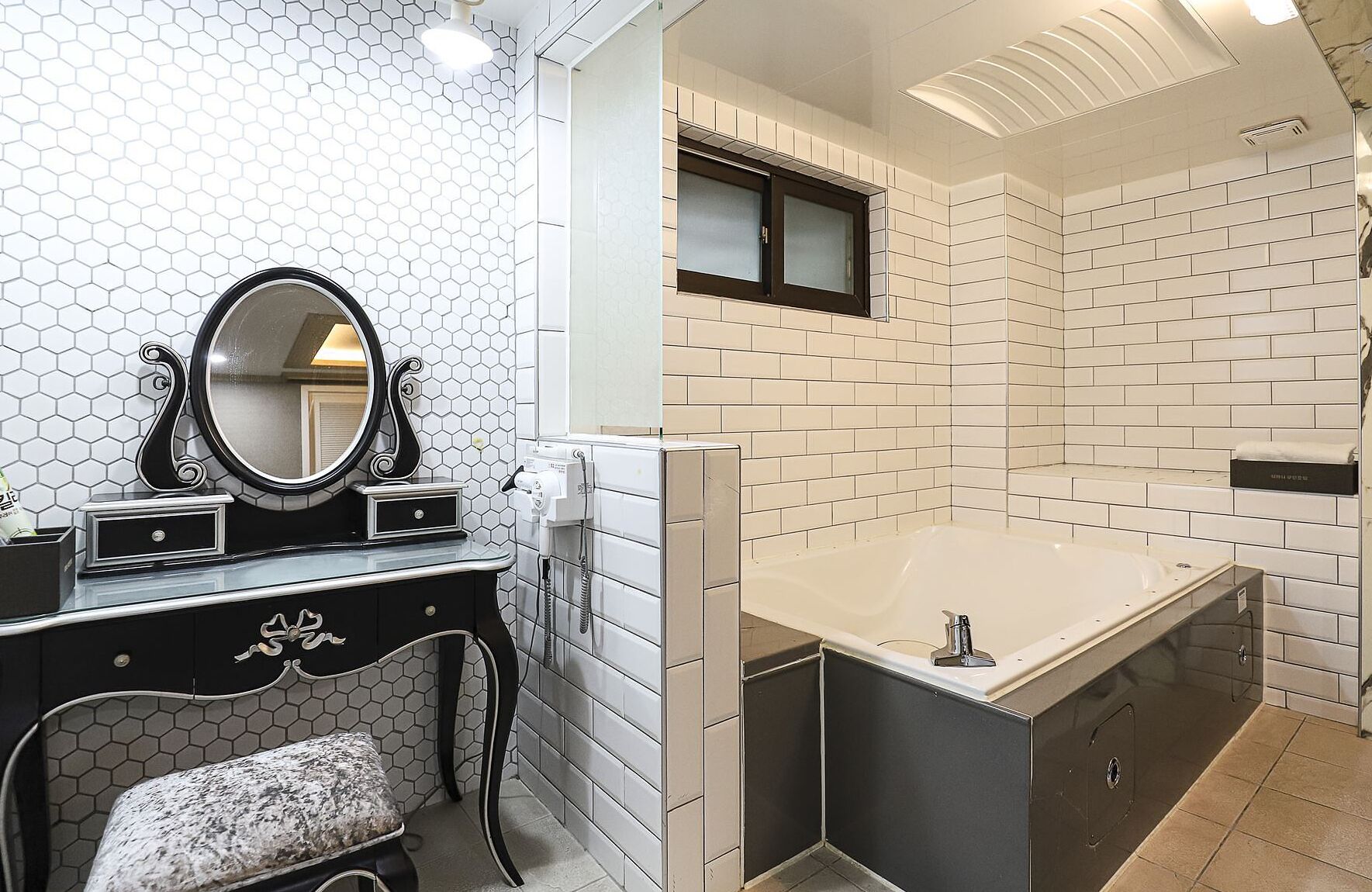 A bathroom with a vanity, a large mirror, a bathtub, and a shower area.
