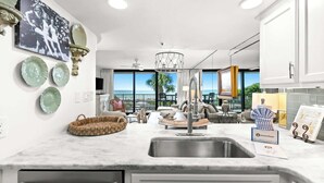 A kitchen with a view of the ocean, a chandelier, and a dining area with a view. - Private Gulf-Front 2BR Condo With Ground-Floor Beach Access (Santa Rosa Beach)