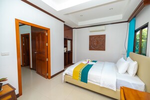 A hotel room with a bed, a wardrobe, a small table, and a window.