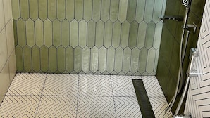 A bathroom with hexagonal green tiles on the walls and a chevron-patterned floor. - Hotel Castle Manor (Vanur)