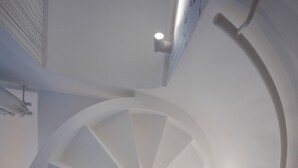 A spiral staircase with a modern design, featuring a series of steps that ascend in a circular pattern. - Villa Francy, Exclusive Villa on the sea with pools (Praiano)