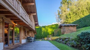 A wooden lodge with a deck, outdoor seating, and a small play area. - Chalet Glaciers | Fireplace | View | Comfy | Quiet (Les Houches)