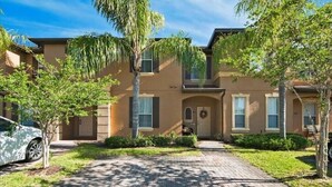 A two-story building with a brick pathway leading to the entrance. - Perfect place for a relaxing family getaway!
 (Davenport)