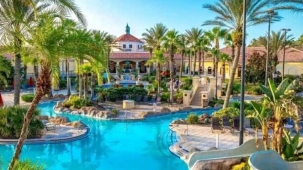 A resort with a central pool, palm trees, and a building with a red roof. - Perfect place for a relaxing family getaway!
 (Davenport)