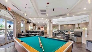 A spacious indoor pool area with a pool table, seating, and a bar area. - Perfect place for a relaxing family getaway!
 (Davenport)