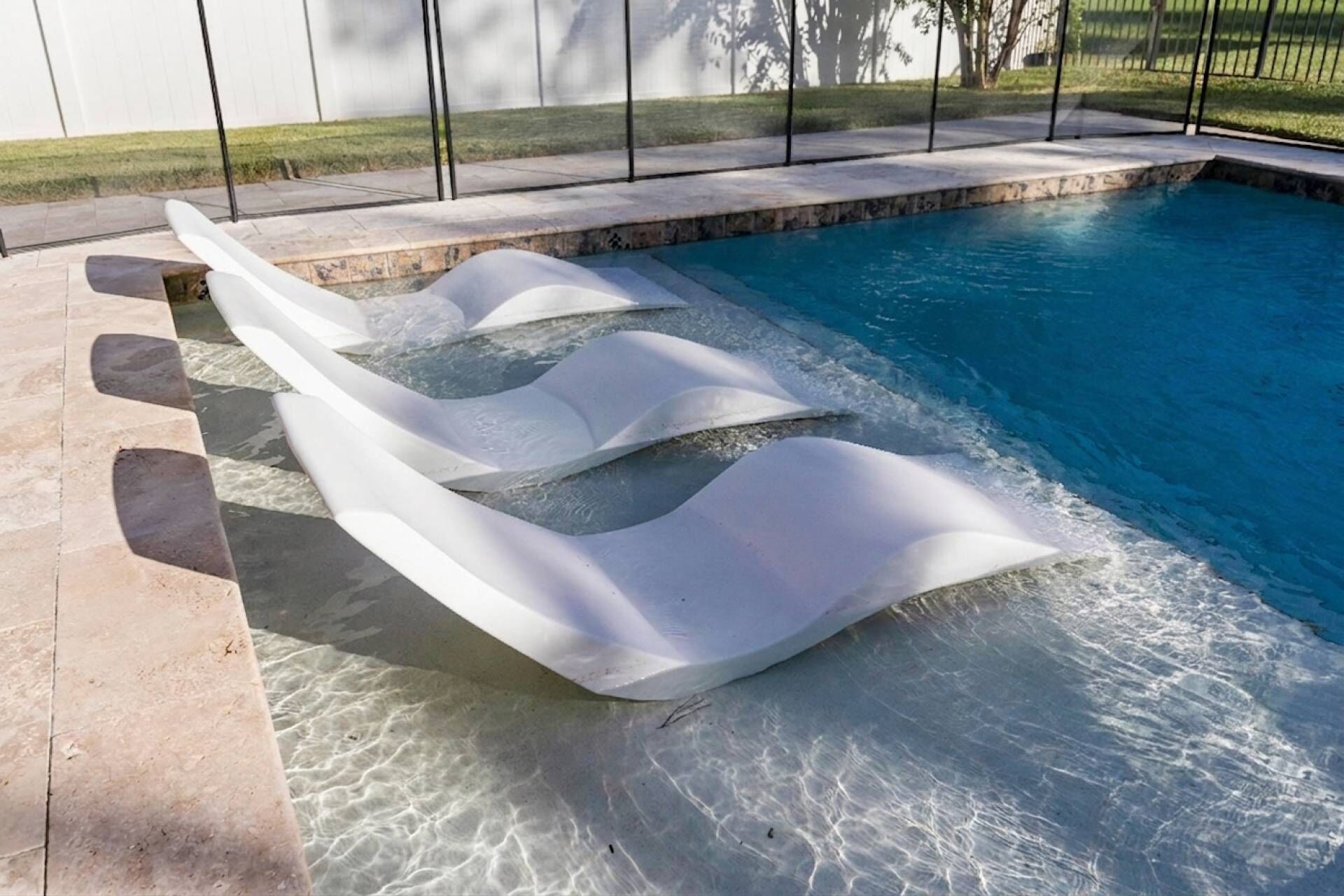 Une piscine dotée d’un système de vagues original et bordée de pierres.
