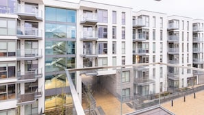 A modern multi-story residential building with balconies, large windows, and a central staircase. - The Hunt Cherrywood (Laughanstown)