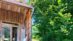 A rustic wooden house with a wooden exterior, a visible window, and a garden with orange flowers. - Beau Chalet Rénové, Avec vue Imprenable sur les Montagnes (Dingy-Saint-Clair)