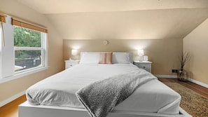 A bedroom with a bed, bedside tables, a window, and a view of greenery outside. - #StayInMyDistrict Arbor Lodge The Ainsworth (Portland)