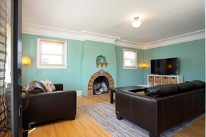 A living room with a fireplace, a sofa, a television, and a lamp.