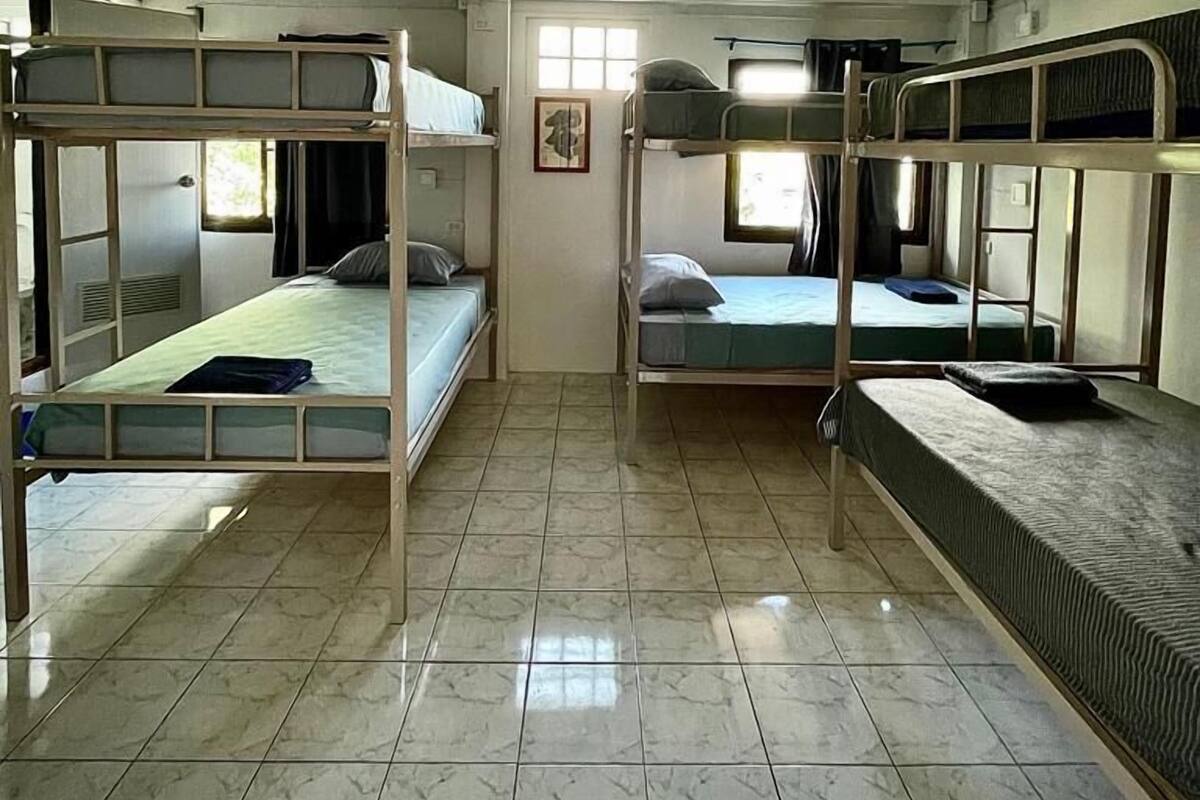 Un dormitorio con literas, suelo de baldosas y ventana que deja entrar luz natural.