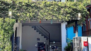 A covered entrance with two motorcycles parked inside, a staircase leading to an upper level, and a gated area with a mailbox. - 56 Chiang Mai Soi 3 (Chiang Mai)