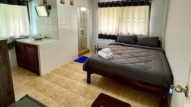 A small, clean room with a bed, a desk, and a shower. - 56 Chiang Mai Soi 3 (Chiang Mai)