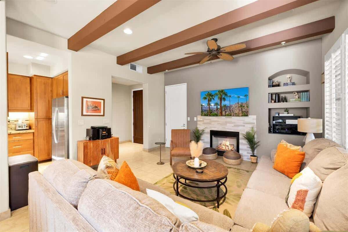 A modern living room with a fireplace, a sofa set, and a coffee table.