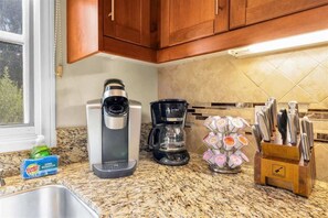 Une cuisine équipée d’une machine à café, d’un mixeur et d’un bloc à couteaux.