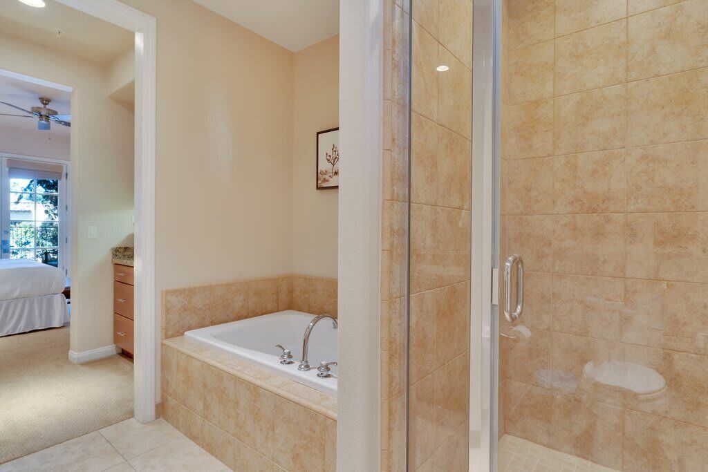 Un baño con ducha a nivel, bañera e inodoro.